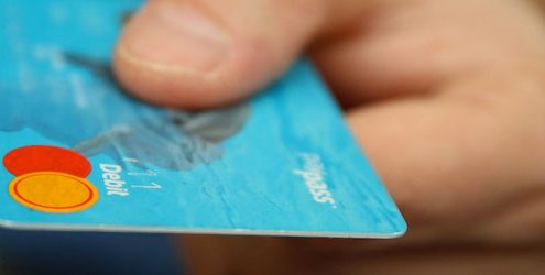 Acquisti d’impulso: mano che sta pagando con carta di credito MasterCard