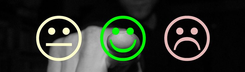 Customer Care: Uomo che indica uno smile sorridente in primo piano di colore verde accompaganto da altri due smile