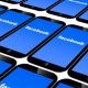 Serie di smartphone che mostrano schermata blu con logo di Facebook