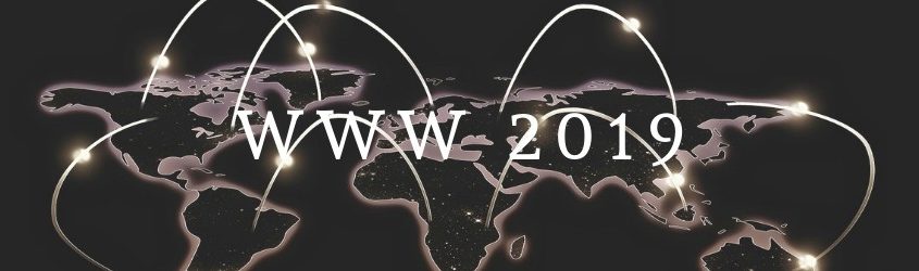 scritta "WWW 2019" su sfondo di una mappa del mondo scura con continenti evidenziati e fasci di luce che li connettono