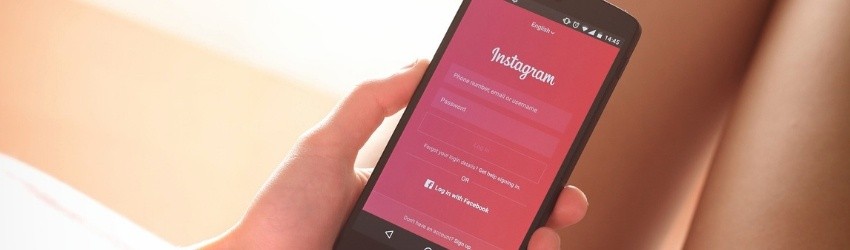 Influencer Marketing: ragazza che ha in mano uno smartphone che mostra la pagina iniziale di Instagram