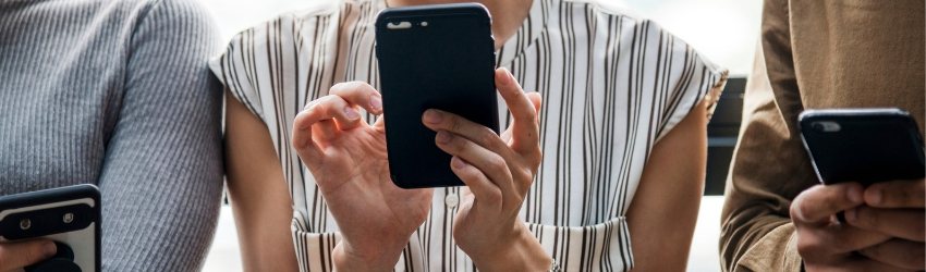 Insight consumatori 2018: zoom su tre persone che utilizzano lo smartphone che hanno fra le mani