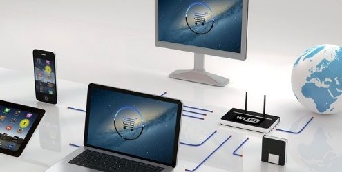 e-commerce: due schermi di computer che mostrano un carrello, collegati a un tablet, uno smartphone, a un router wi-fi e al mondo su sfondo bianco lucido
