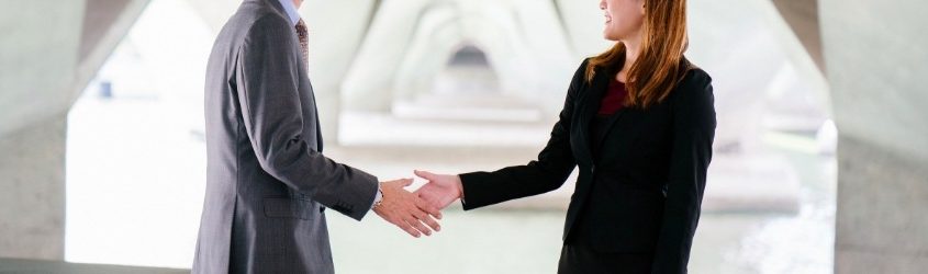 Non vendi quanto vorresti: donna e uomo che si stringono la mano ad un incontro commerciale